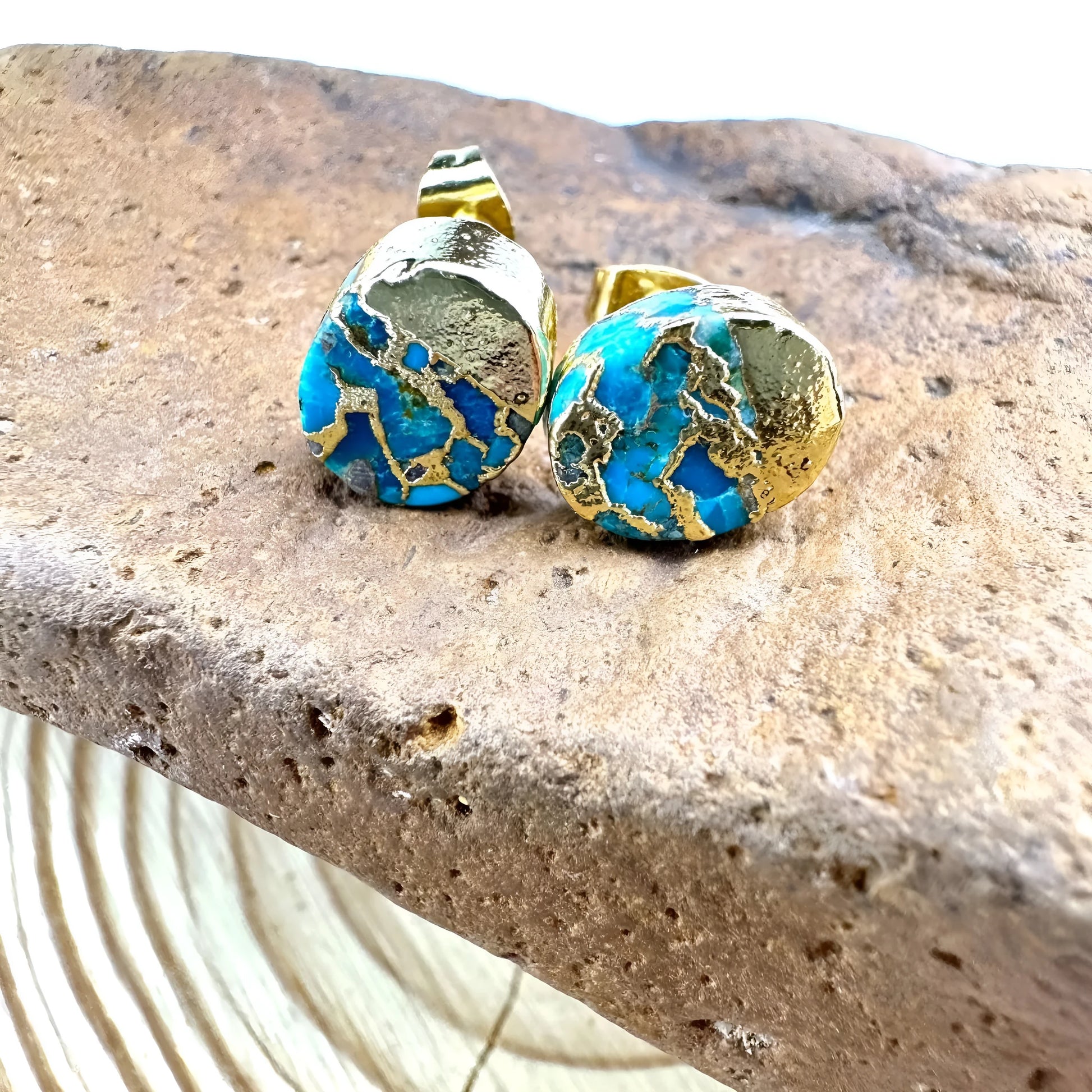Handmade natural stone bohemian style stud earrings with an irregular organic shape on a grey background.