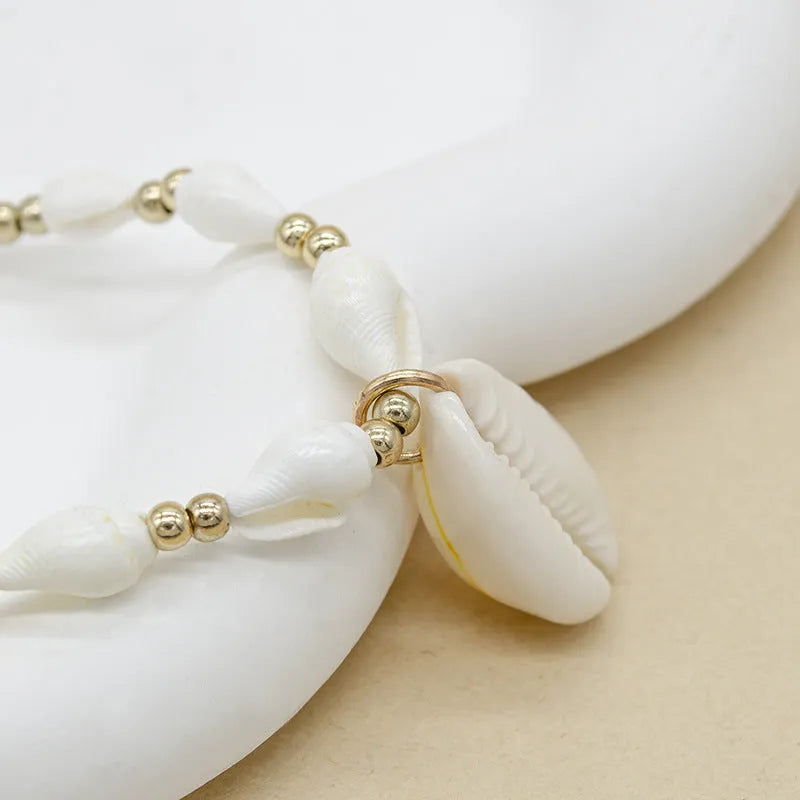 White shell necklace with conch pendant on 45cm chain, electroplated finish.