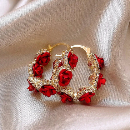 Red alloy rose flower earrings with ear clip fastening shown as complete pair