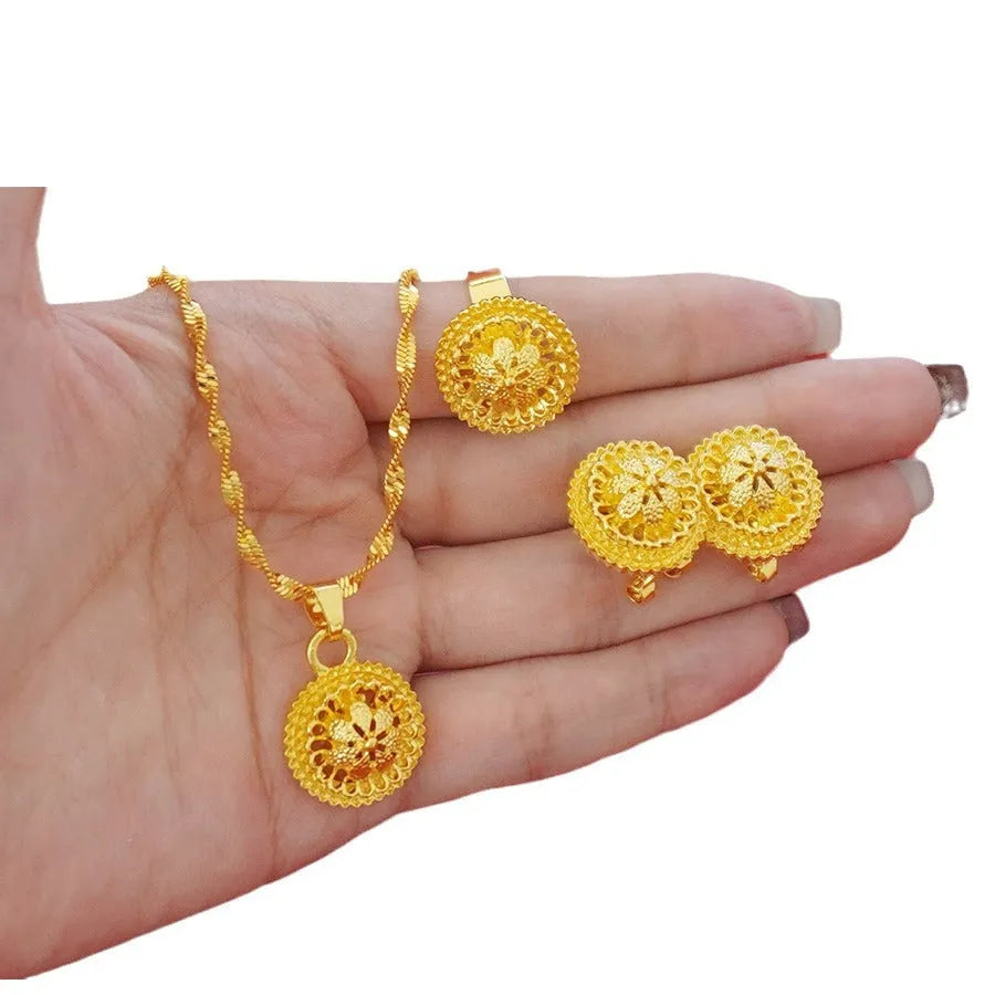 Gold-plated three-piece jewellery set with a three-layer flower design necklace, matching earrings, and ring on a white background.