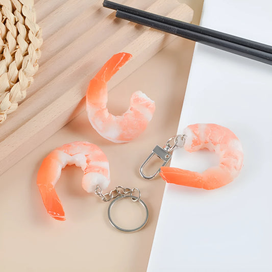 White simulated shrimp-shaped PVC keychain with a silver door buckle attachment.