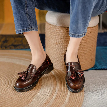 Women's brown leather loafers with tassel detail and a chunky low heel.