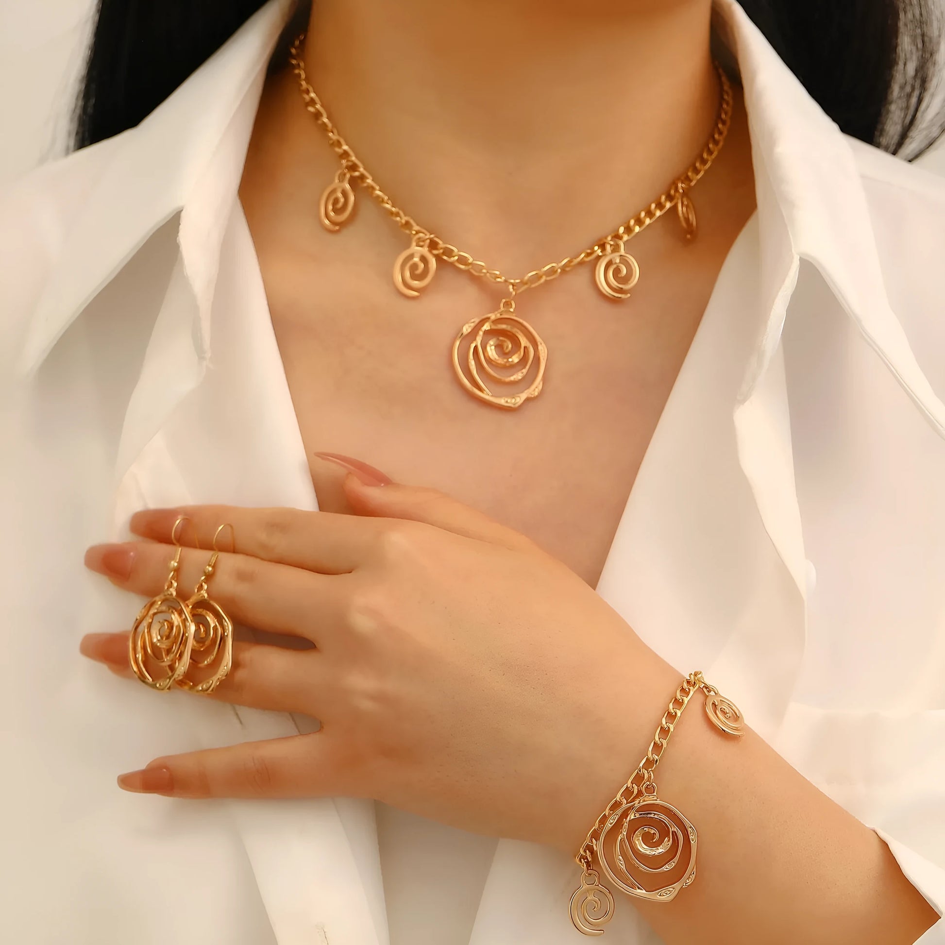 Gold spiral donut alloy jewellery set showing necklace, bracelet, and ear hooks on a plain background.