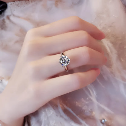 White gold plated geometric ring with a six-claw set zircon stone on a model's finger.
