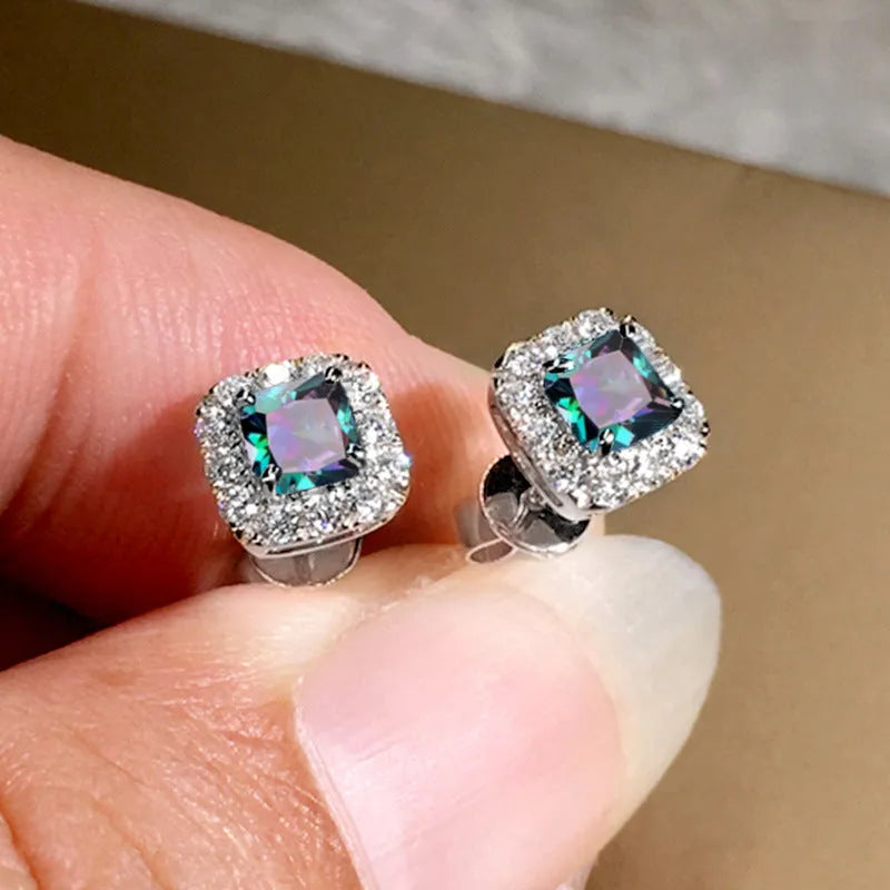 A pair of bright green square zircon stud earrings with a gold electroplated setting on a white background.