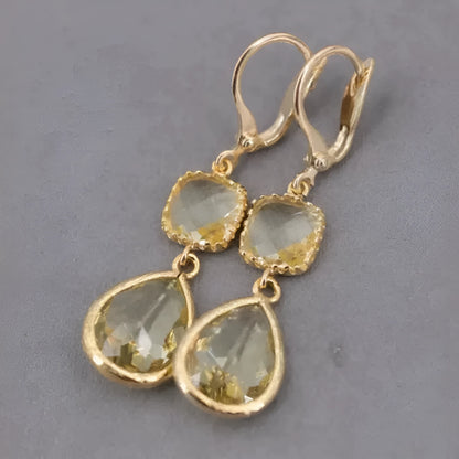 Gold geometric drop earrings with long crystal fringe and water droplet design.