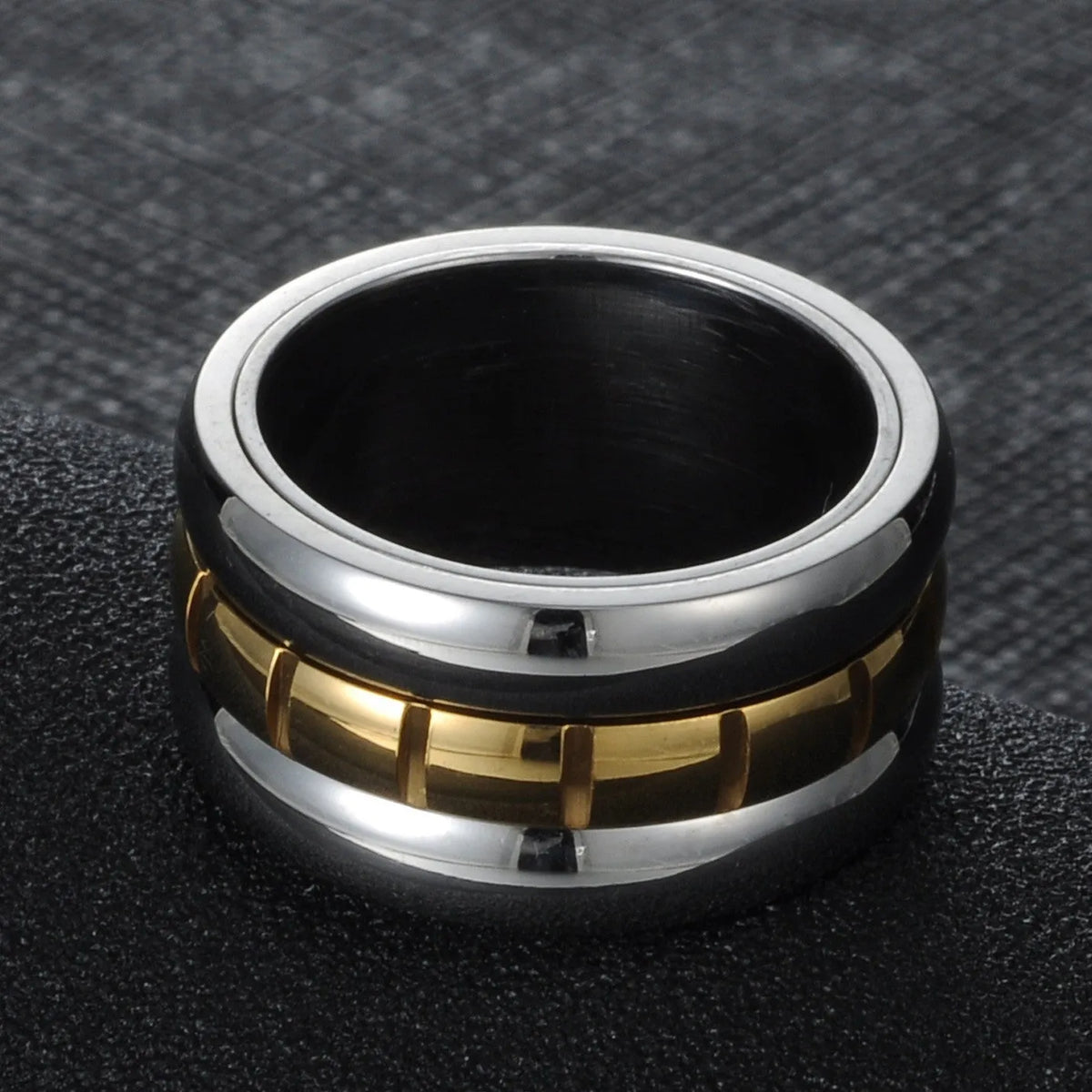 Gold ultra-wide titanium steel men's ring with a rotatable tail component on a finger.