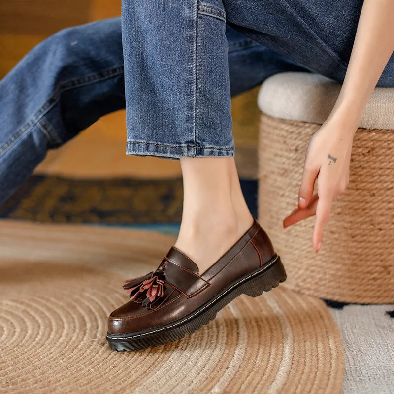Women's brown leather loafers with tassel detail and a chunky low heel.