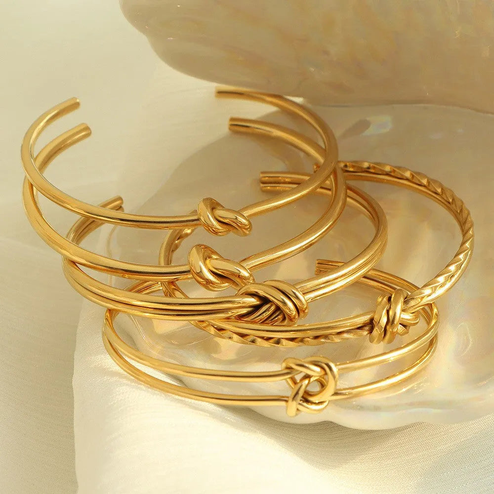 Women's knotted C-shaped open double-layer stainless steel bracelet with gold plating.
