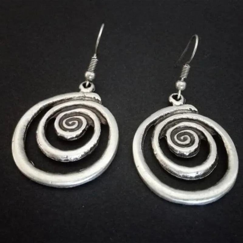 A pair of silver spiral geometric earrings with a distressed texture, shown from the front.