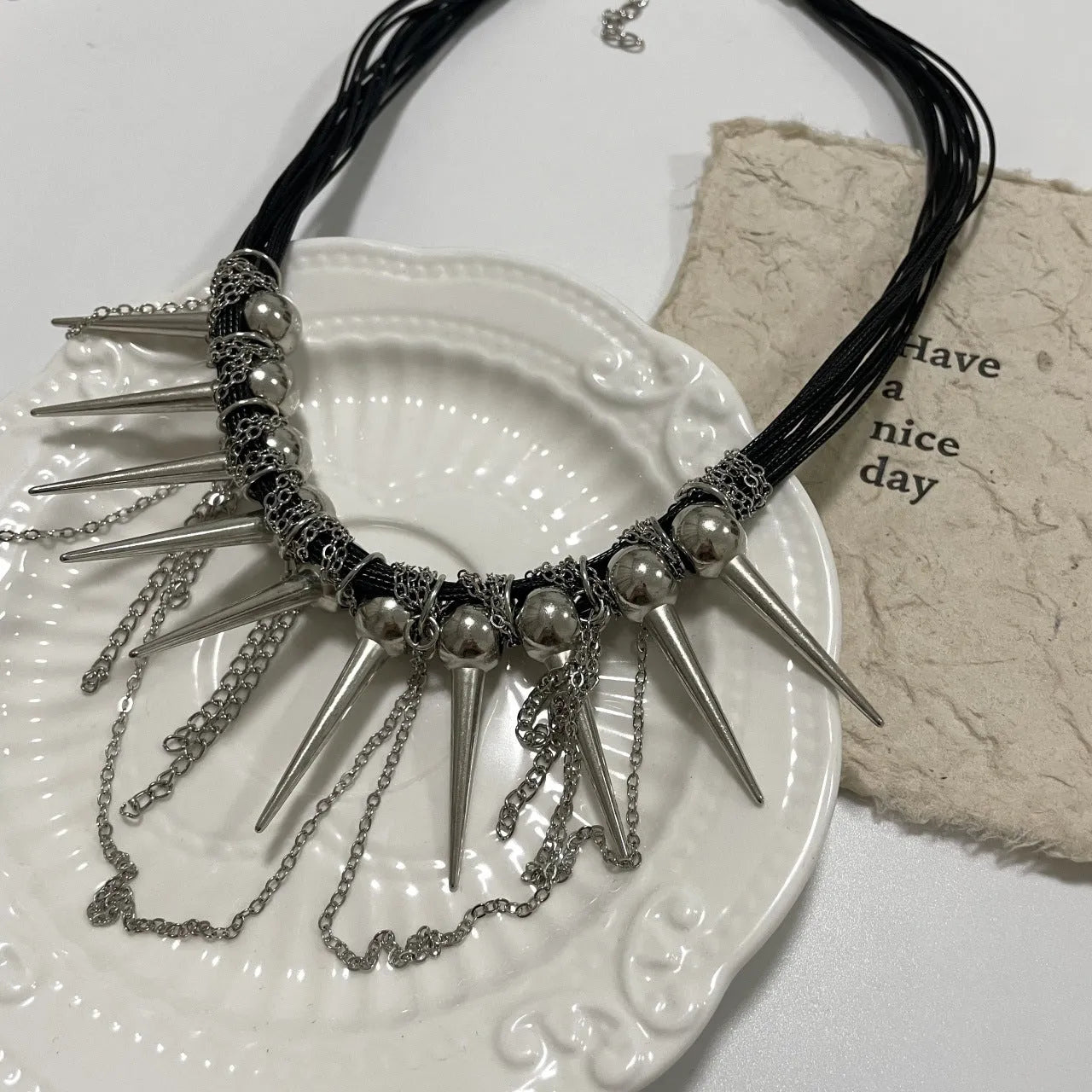 Women's leather necklace with electroplated rivet accents and round beads in winding tassel design
