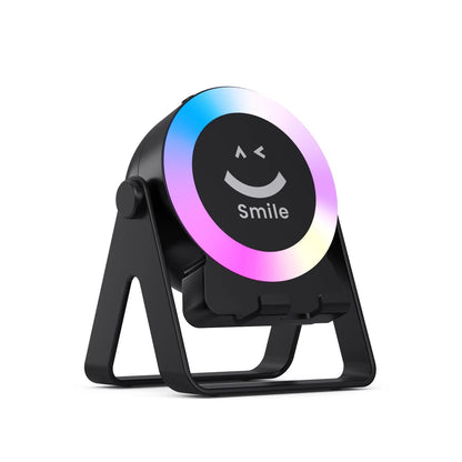 Black and white wireless induction charging Bluetooth speaker with colourful LED lights on a desk.