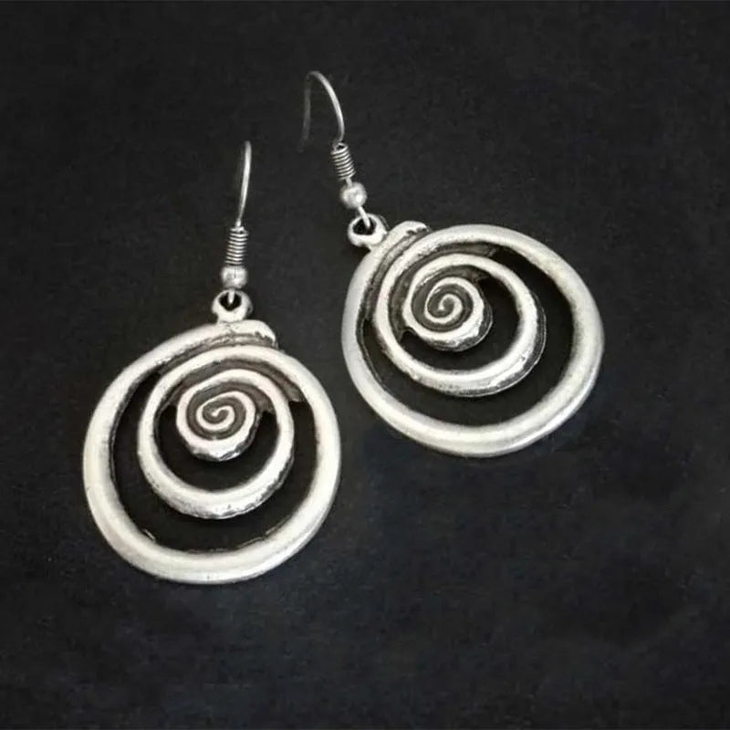 A pair of silver spiral geometric earrings with a distressed texture, shown from the front.