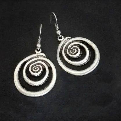 A pair of silver spiral geometric earrings with a distressed texture, shown from the front.