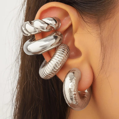 Set of four geometric gold and silver clip-on earrings for non-pierced ears, displayed on a flat surface.