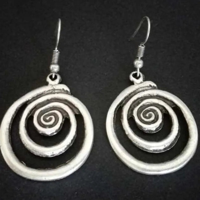 A pair of silver spiral geometric earrings with a distressed texture, shown from the front.