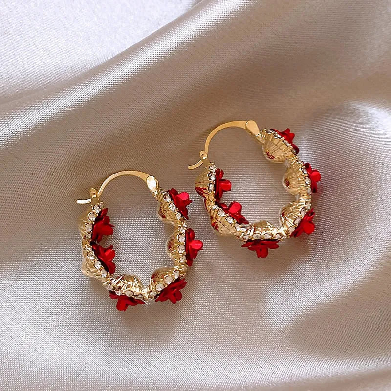 Red alloy rose flower earrings with ear clip fastening shown as complete pair