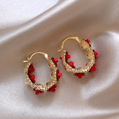 Red alloy rose flower earrings with ear clip fastening shown as complete pair