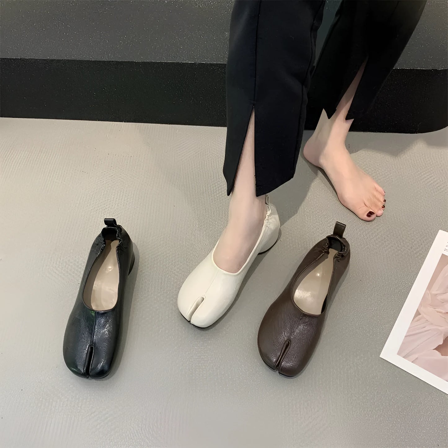 Women's black split-toe chunky heel pumps with round toe and low heel on a white background