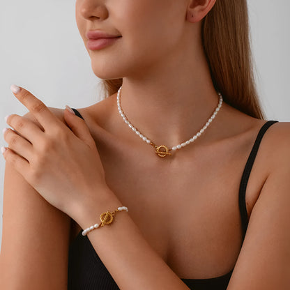 Freshwater pearl and geometric stainless steel necklace and bracelet set for women on a white background.