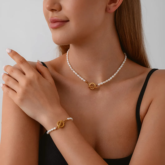 Freshwater pearl and geometric stainless steel necklace and bracelet set for women on a white background.