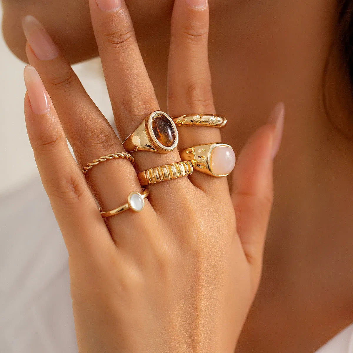 Six irregular geometric alloy rings with light gold electroplated finish arranged as a jewellery set
