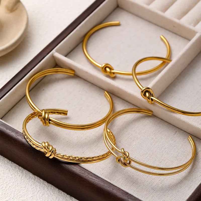 Women's stainless steel bracelet with 18K gold plating, featuring a knotted C-shaped open double-layer design in an adjustable fashion OL style, available in gold and silver colour finishes.