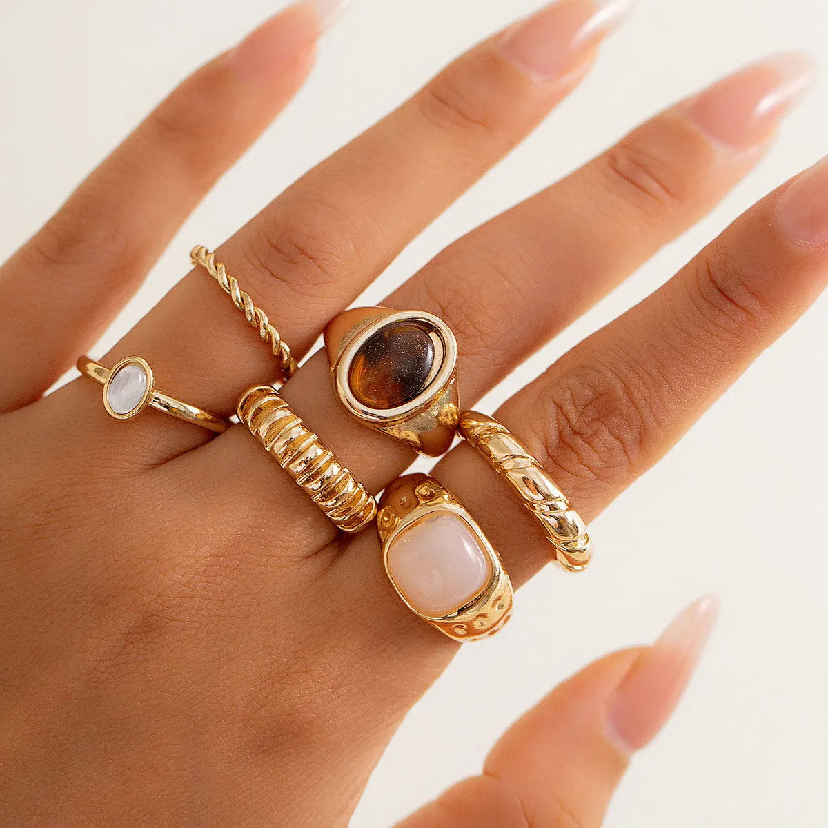 Six irregular geometric alloy rings with light gold electroplated finish arranged as a jewellery set
