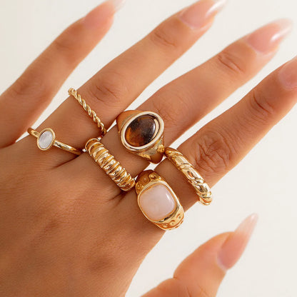 Six irregular geometric alloy rings with light gold electroplated finish arranged as a jewellery set