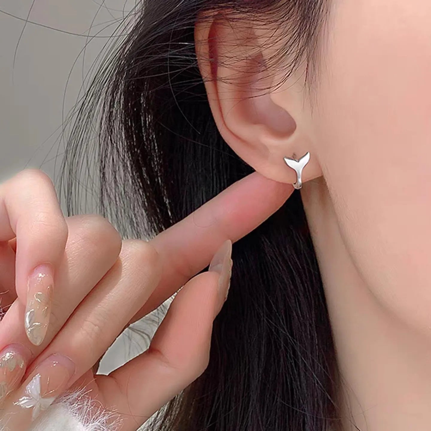 A pair of women's simple fishtail drop earrings with a gold electroplated finish on a copper base.