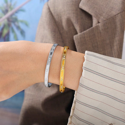 Stainless steel open-end bracelet with a buckle clasp in a gold electroplated finish featuring circle design elements.