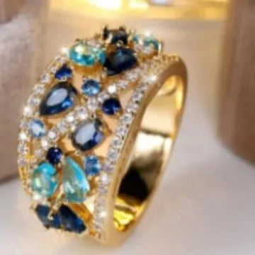 Women's round hollow copper ring showing gold and platinum plating options with sapphire blue and white accents