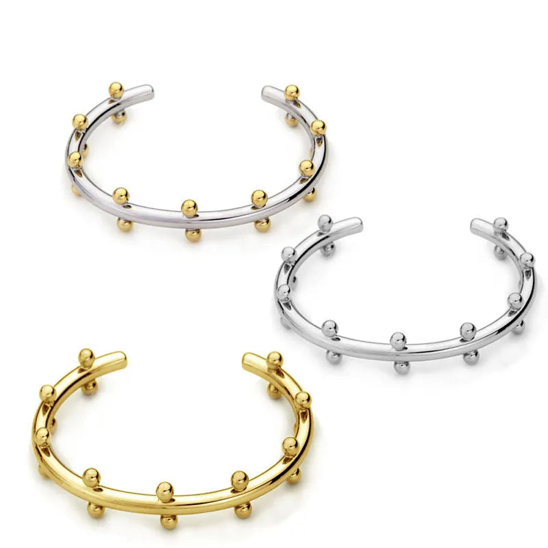 C-shaped stainless steel bracelet with textured rivets and bean beads in gold finish