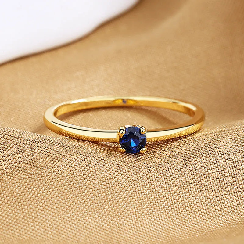 Twin Style copper geometric circle ring with a single diamond, shown in blue, green, red, or white.