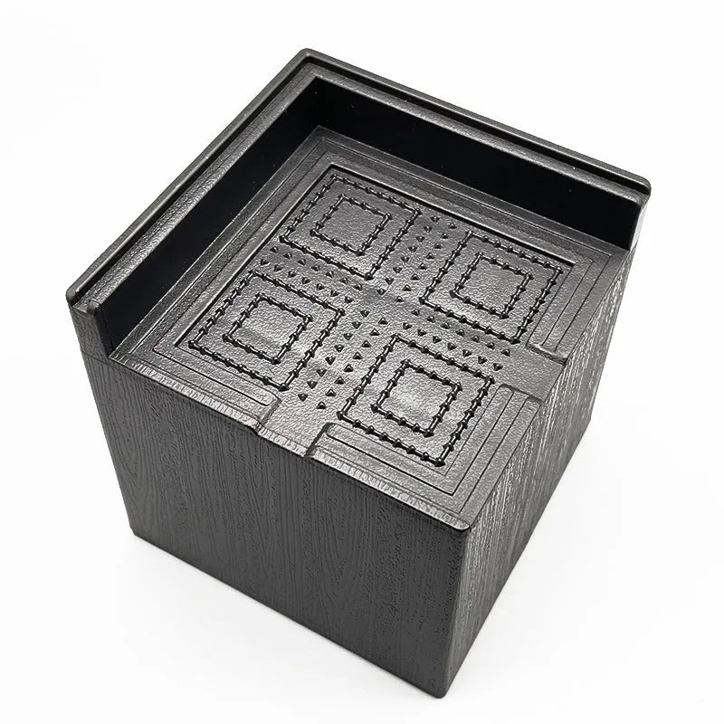 Set of four round black plastic furniture risers, each 3cm tall, on a wooden floor.