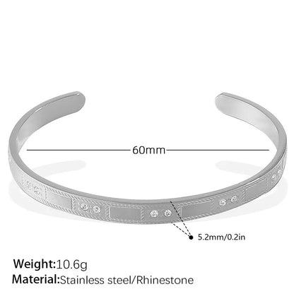Stainless steel open-end bracelet with a buckle clasp in a gold electroplated finish featuring circle design elements.