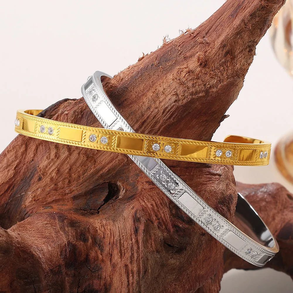 Stainless steel open-end bracelet with a buckle clasp in a gold electroplated finish featuring circle design elements.