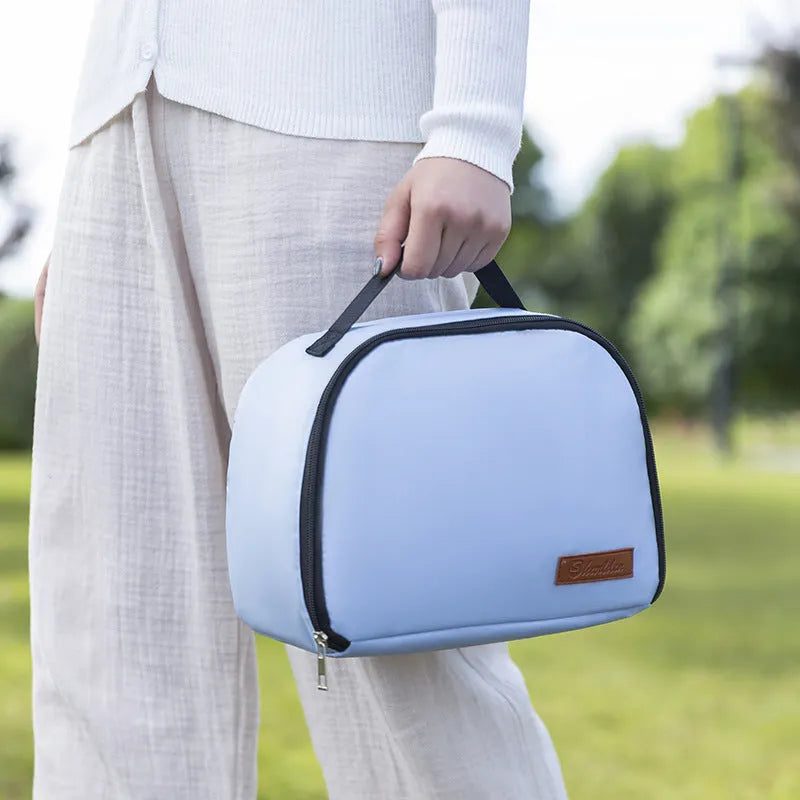 Insulated lunch box bag in sapphire blue textured cloth, shown with a lunch box inside.