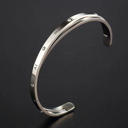 Women's open-ended stainless steel bracelet with a central inlaid zircon stone in rose gold colour.