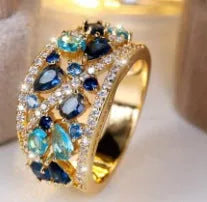 Women's round hollow copper ring showing gold and platinum plating options with sapphire blue and white accents