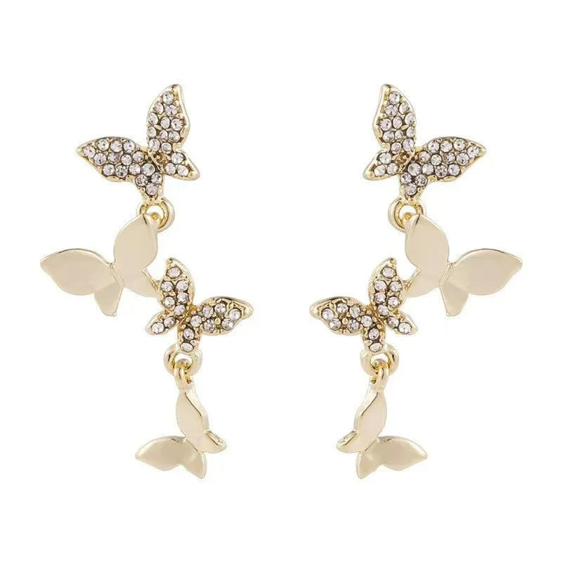 A pair of gold-coloured copper drop earrings with four detailed butterfly charms.