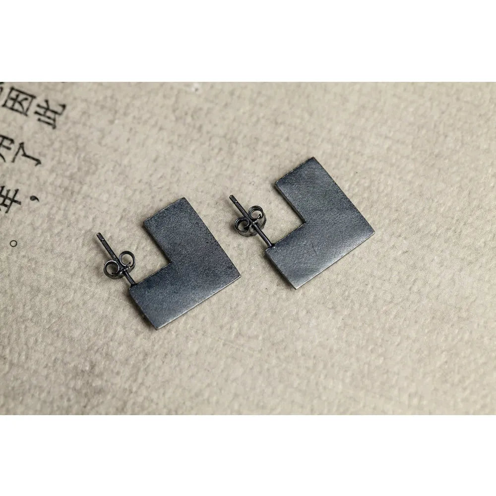 Oxidised black sterling silver earrings with a geometric square shape and minimalist ring design.