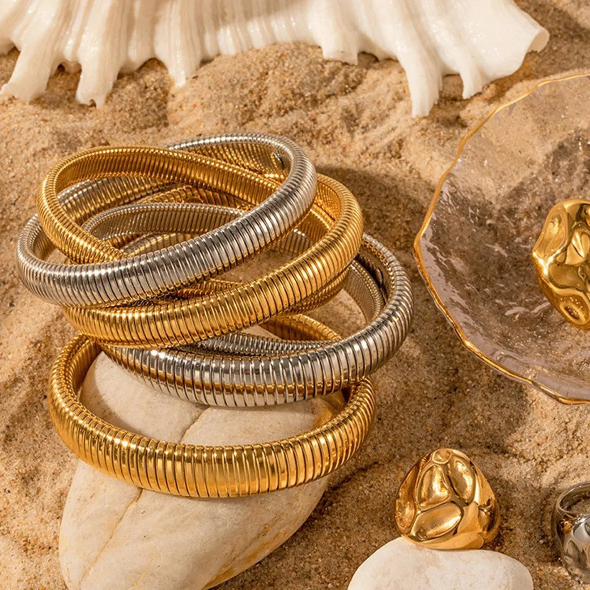 Women's titanium steel elastic bracelet with a vertical stripe pattern in gold, shown on a wrist.