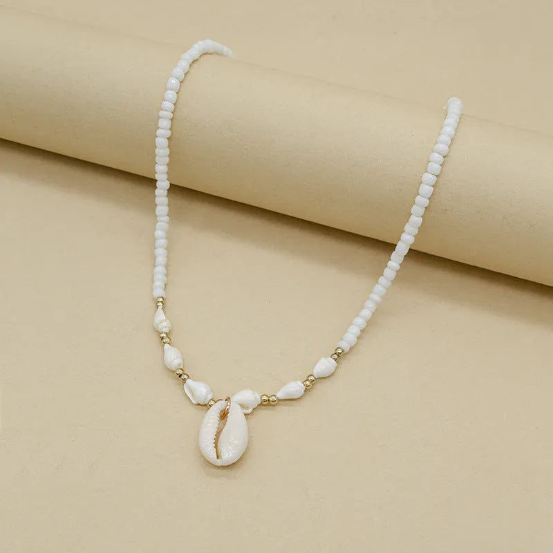 White shell necklace with conch pendant on 45cm chain, electroplated finish.