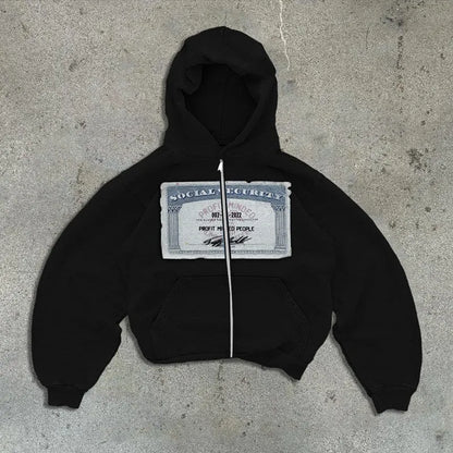 A person wearing a black loose-fit zip-up hoodie with a hood and front pockets.