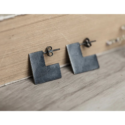 Oxidised black sterling silver earrings with a geometric square shape and minimalist ring design.