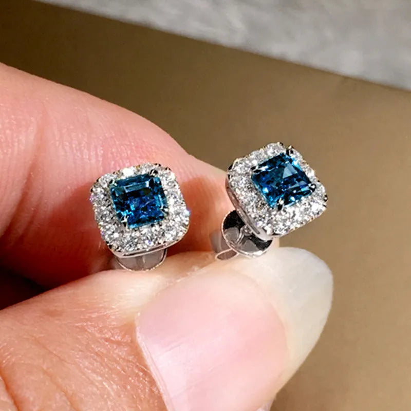 A pair of bright green square zircon stud earrings with a gold electroplated setting on a white background.