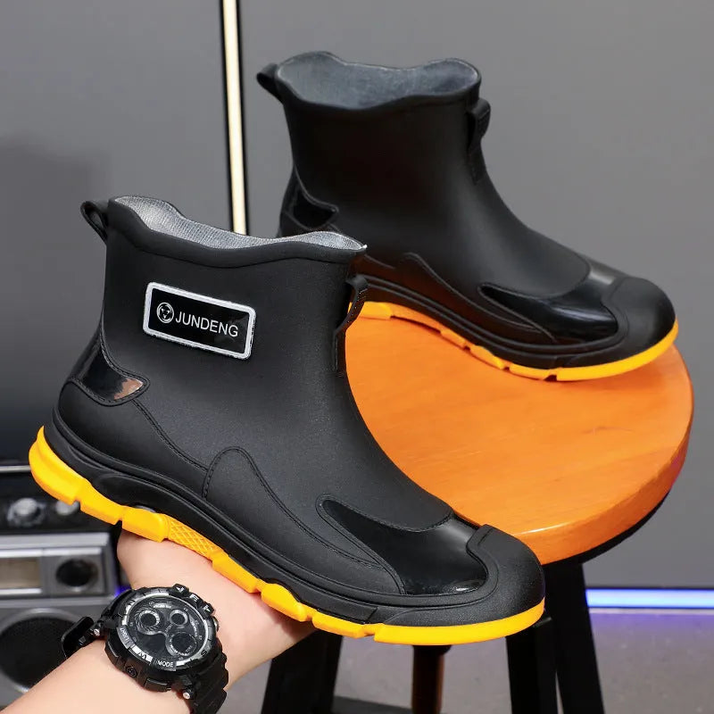 Women's short tube PVC waterproof boots in black with a round toe and flat plastic sole.