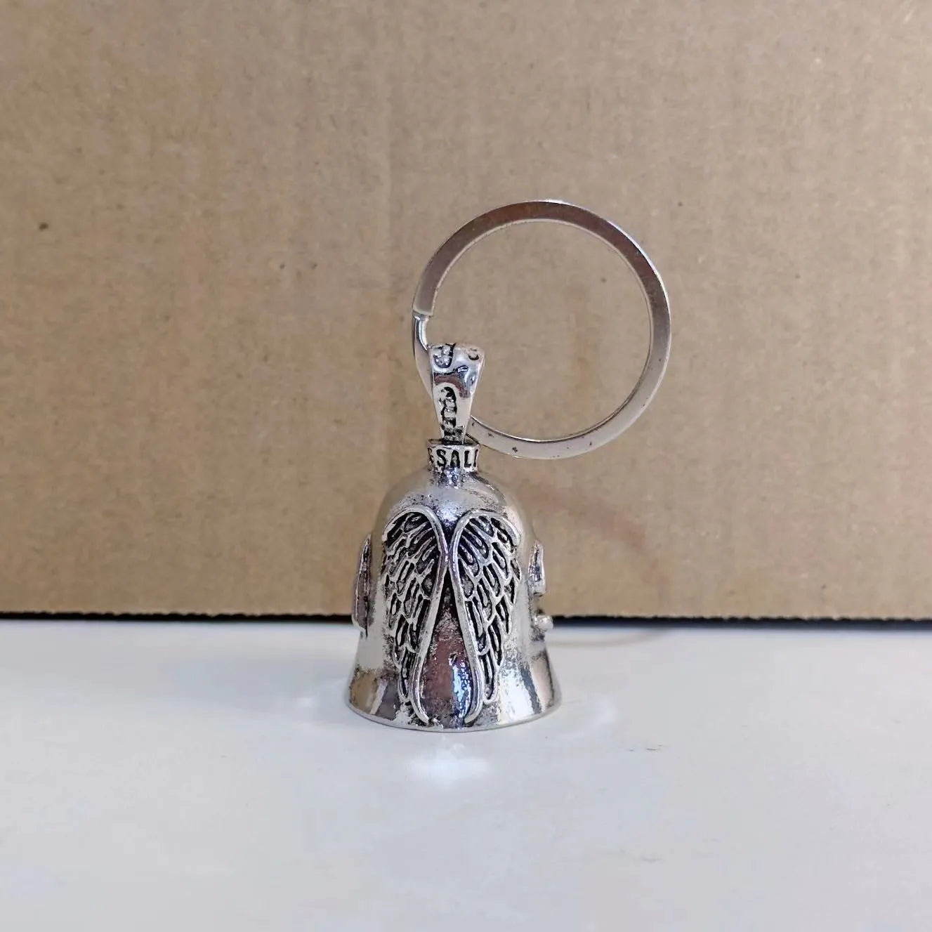 Vintage silver-tone angel wings feather keychain and necklace on a white background.