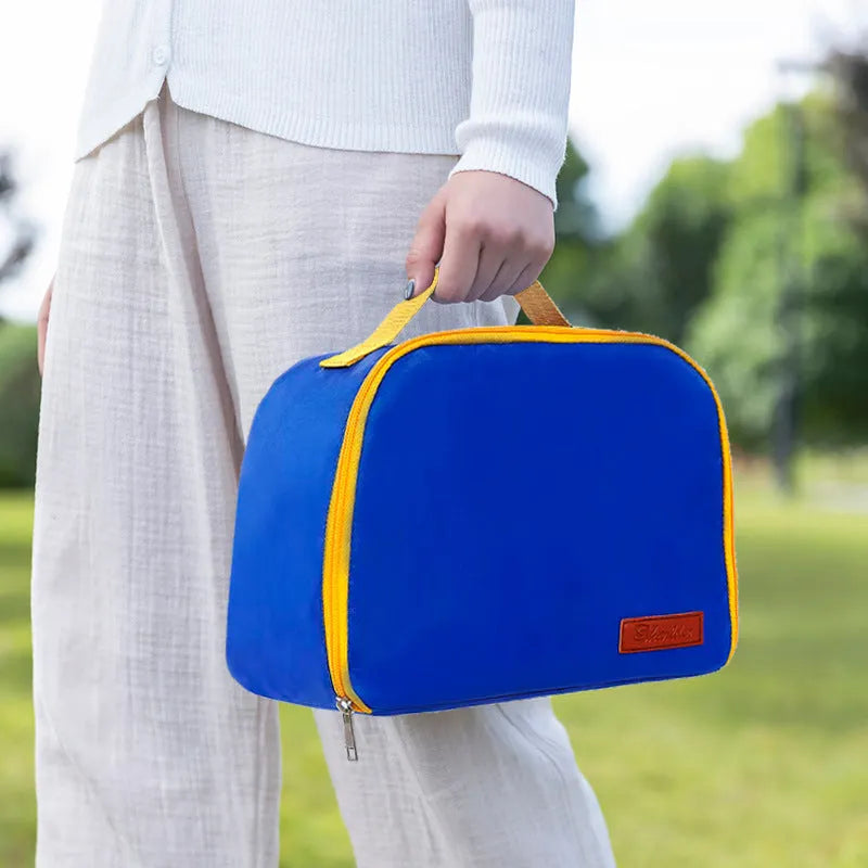 Insulated lunch box bag in sapphire blue textured cloth, shown with a lunch box inside.